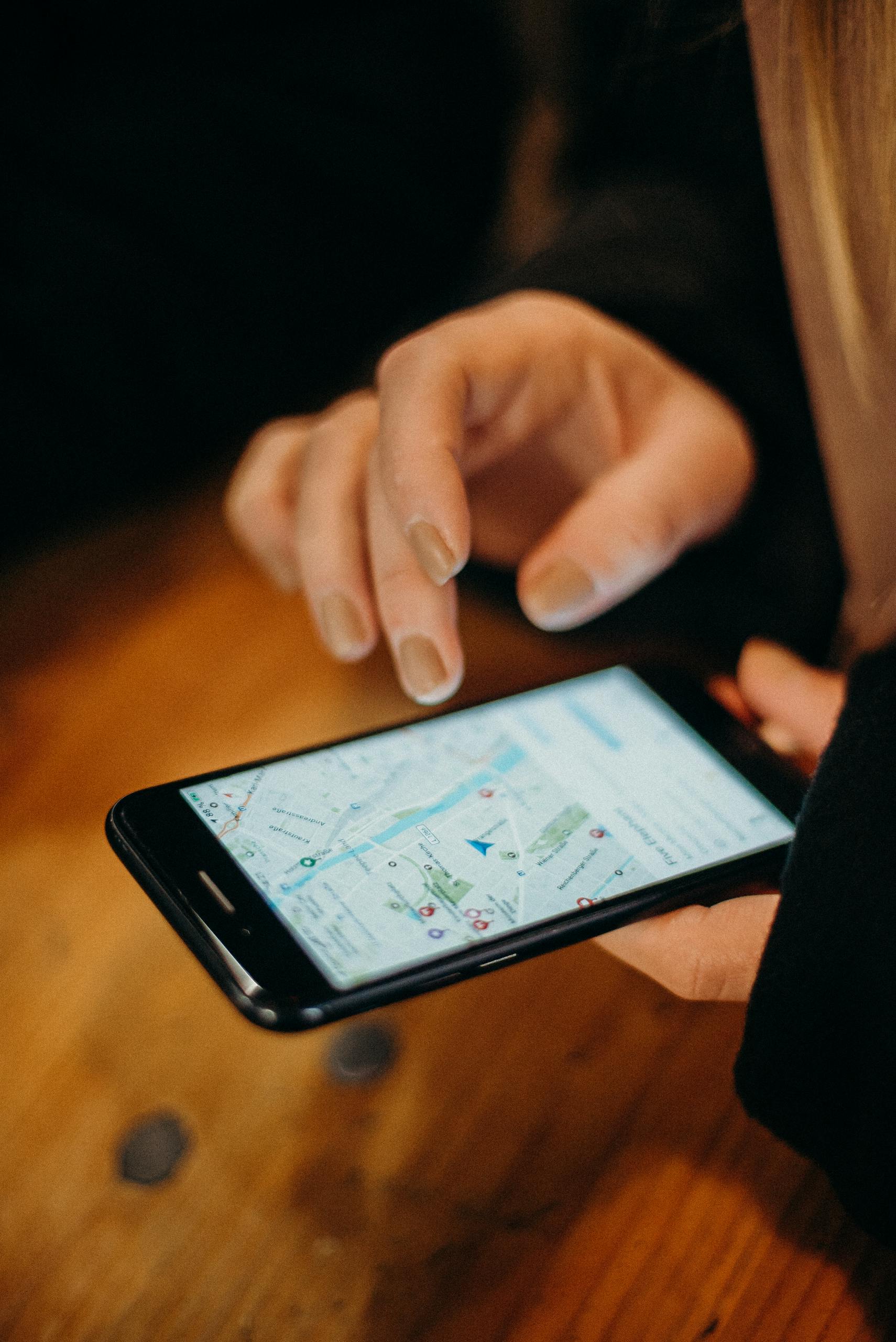 Home 2 Local SEO - Close-up of a hand using a smartphone displaying a map for navigation.