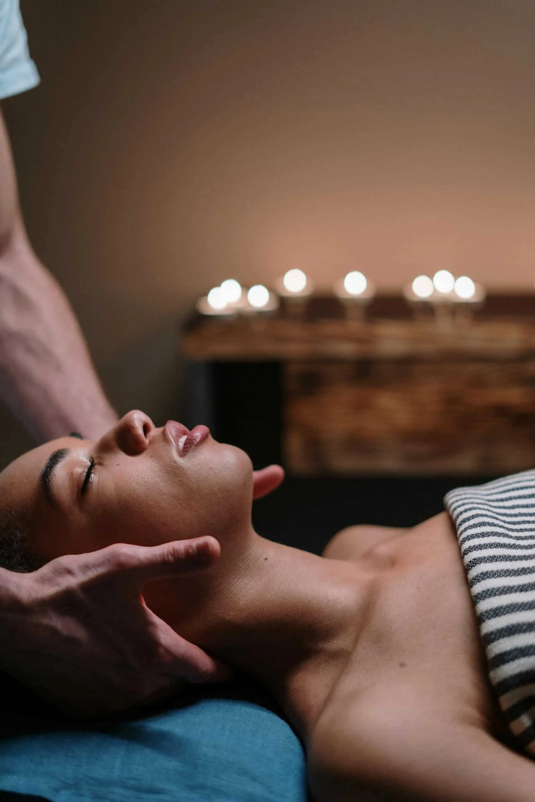 Home 3 A woman enjoying a relaxing face massage in a tranquil spa setting.